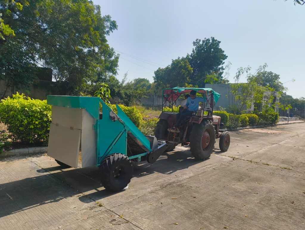 A tractor towing the Sandster attachment on a paved road